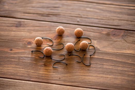 Carp fishing. Different of carp boilies and accessories for carp fishing isolated on wooden background.