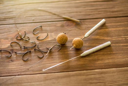 Carp fishing. Different of carp boilies and accessories for carp fishing isolated on wooden background.