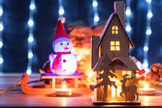 Christmas gingerbread house decoration on defocused lights background.