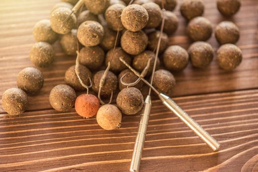 Carp fishing. Different of carp boilies and accessories for carp fishing isolated on wooden background.