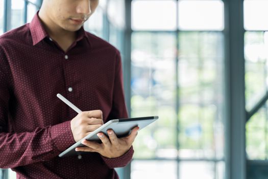 Close up Men are Using the tablet and holding it on hand. He use tablet to work, check emails, teleconferences, or social networks. During work from home at the Home Office