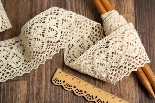 knitted beige openwork linen ribbon tapes in rural style of rustics cotton eco natural on wood ground
