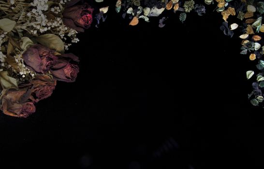 Romantic background in soft autumn colors with dried roses and pot pourri on black background