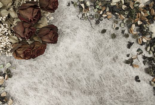 Romantic background in soft autumn colors with dried roses and pot pourri on white rice paper