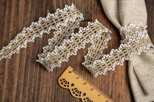knitted beige openwork linen ribbon tapes in rural style of rustics cotton eco natural on wood ground