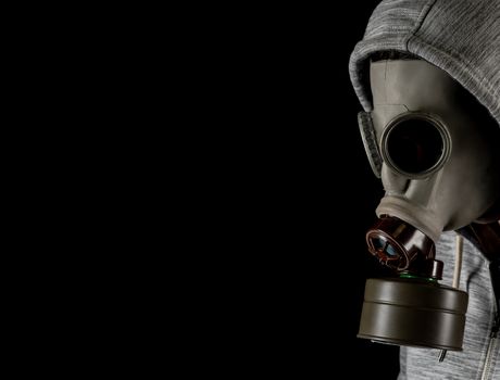 man in a gas mask on a black background. protection against viruses