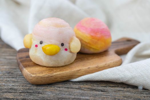 Cute Chinese Pastry or moon cake stuffed with salted egg yolk on wood plate