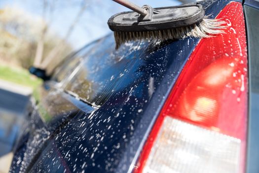 Hand wash the car using a brush with foam.