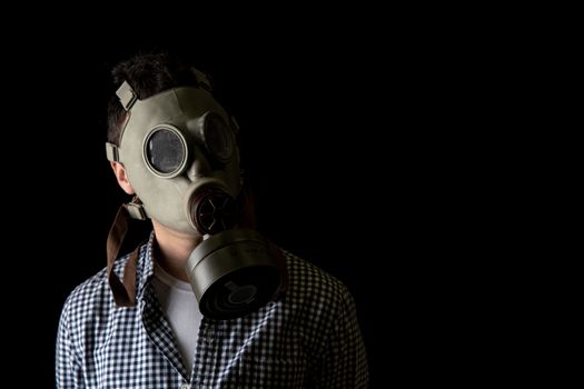 man in a gas mask on a black background. copy space.