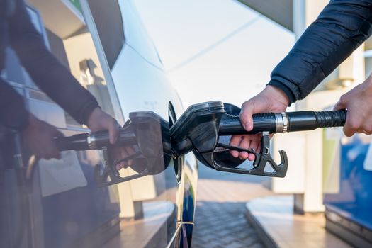 refueling a passenger car tank at a gas station.