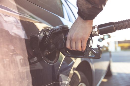 refueling a passenger car tank at a gas station.