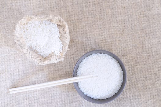 Sack of rice and bowl on a burlap.