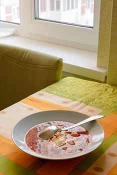 Simple traditional homemade red Ukrainian Borscht with smetana cream in a white porcelain plate
