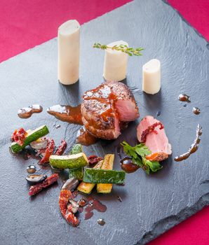 Fillet of beef with zucchini and hearts of palm, on a slate