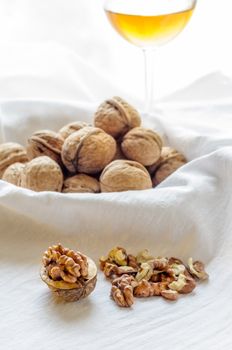 Close up of a heap of dry tasty walnuts on a table with tablecloth, and wine