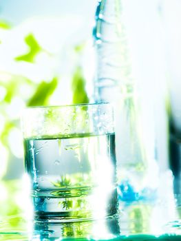 Fresh and cold water in a glass. The transparency is enhanced by the backlight and the blurred effect in the background