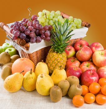 A composition of various fresh fruits with some fruits in a basket