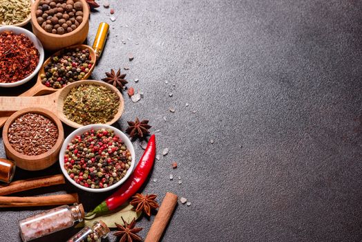 A set of spices and herbs. Indian cuisine. Pepper, salt, paprika, basil and other on a dark background. Top view. Free copy space.