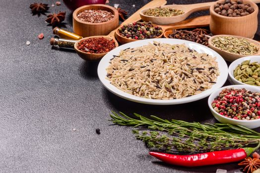 A set of spices and herbs. Indian cuisine. Pepper, salt, paprika, basil and other on a dark background. Top view. Free copy space.