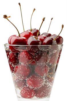 Closeup of fresh and natural red cherries in a glass with water and bubbles