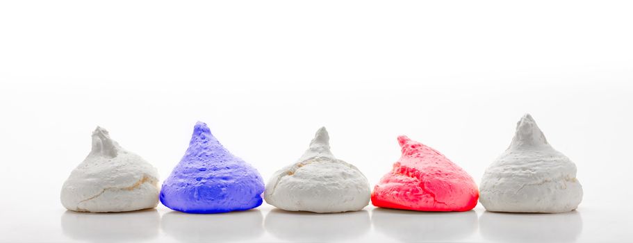 Five  Blue White and Red french meringues aligned in a row, on white background