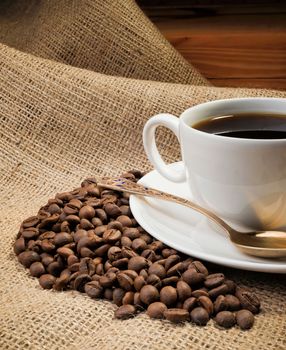 A warm cup of coffee with coffee beans