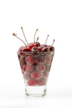 Fresh and natural red cherries in a glass with water and bubbles