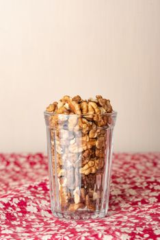 Fresh peeled walnuts in a glass on a wooden table, with negative space for copy text