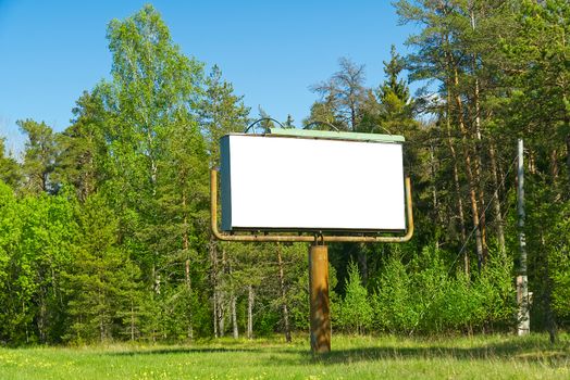 white billboard on a background of green forest. suitable for advertising. Blank billboard and outdoor advertising. white Mockup poster outside in forest