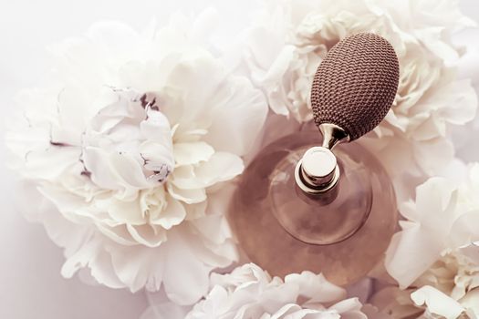 Retro fragrance bottle as luxury perfume product on background of peony flowers, parfum ad and beauty branding design