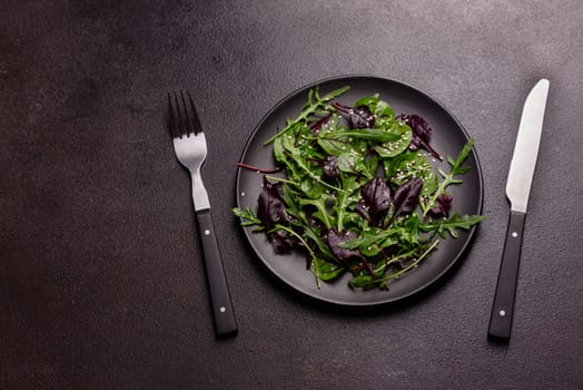 Healthy food, salad mix with arugula, spinach, bulls blood, beet leafs and micro greens. Food background, copy space