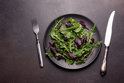 Healthy food, salad mix with arugula, spinach, bulls blood, beet leafs and micro greens. Food background, copy space