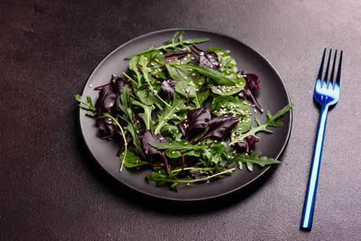 Healthy food, salad mix with arugula, spinach, bulls blood, beet leafs and micro greens. Food background, copy space