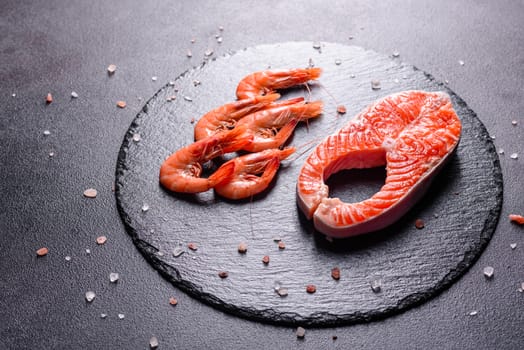 Raw trout red fish steak served with herbs and lemon and olive oil on a dark background. Cooking Salmon, sea food. Healthy eating concept