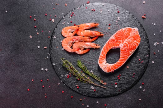 Raw trout red fish steak served with herbs and lemon and olive oil on a dark background. Cooking Salmon, sea food. Healthy eating concept