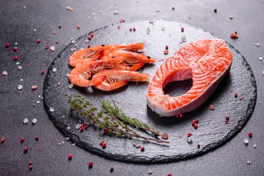 Raw trout red fish steak served with herbs and lemon and olive oil on a dark background. Cooking Salmon, sea food. Healthy eating concept