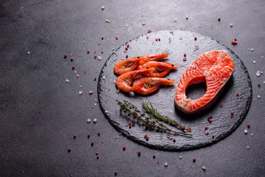 Raw trout red fish steak served with herbs and lemon and olive oil on a dark background. Cooking Salmon, sea food. Healthy eating concept