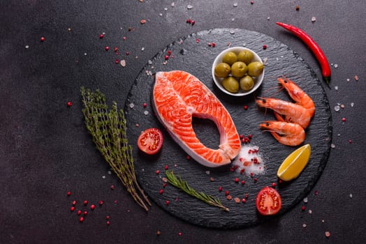 Raw trout red fish steak served with herbs and lemon and olive oil on a dark background. Cooking Salmon, sea food. Healthy eating concept