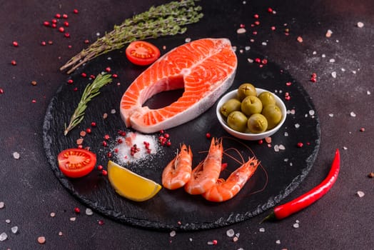 Raw trout red fish steak served with herbs and lemon and olive oil on a dark background. Cooking Salmon, sea food. Healthy eating concept