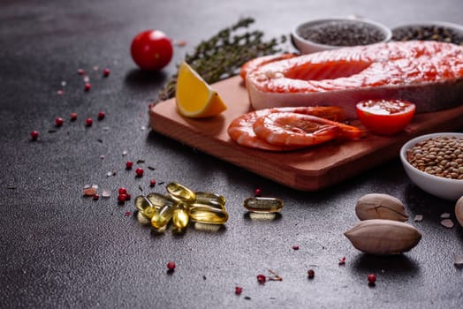 Raw trout red fish steak served with herbs and lemon and olive oil on a dark background. Cooking Salmon, sea food. Healthy eating concept
