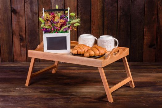 Delicious breakfast with fresh croissants and ripe berries on a beautiful wooden table