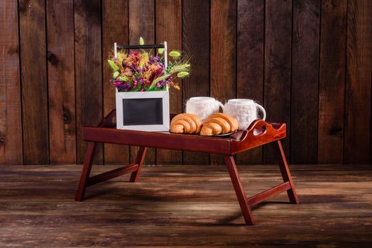 Delicious breakfast with fresh croissants and ripe berries on a beautiful wooden table