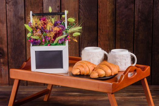Delicious breakfast with fresh croissants and ripe berries on a beautiful wooden table