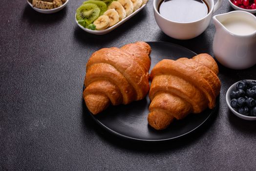 Delicious breakfast with fresh croissants and ripe berries on a beautiful wooden table