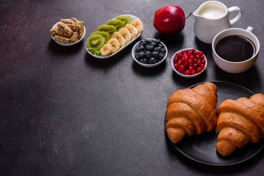 Delicious breakfast with fresh croissants and ripe berries on a beautiful wooden table