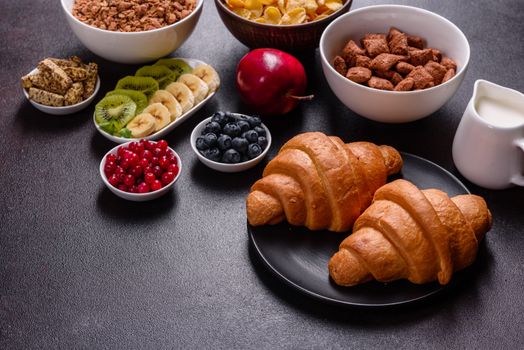 Delicious breakfast with fresh croissants and ripe berries on a beautiful wooden table