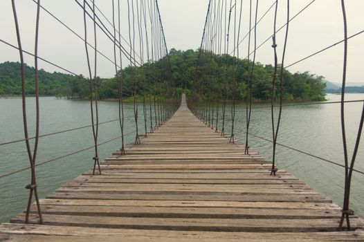 A suspension bridge over the water for pedestrians to cross the shore