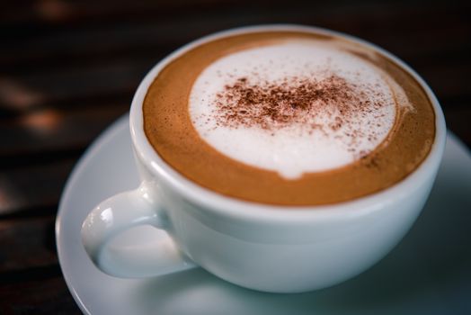 Coffee drink in the white coffee cup on wood table for serve to customers at coffee shop cafe or restaurant