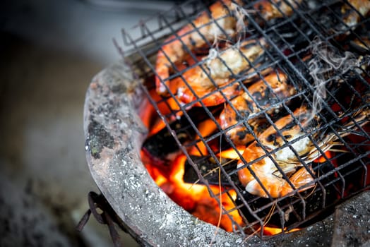 Grilled shrimp (Giant freshwater prawn) grilling with charcoal for sale at Thai street food market or restaurant in Bangkok Thailand