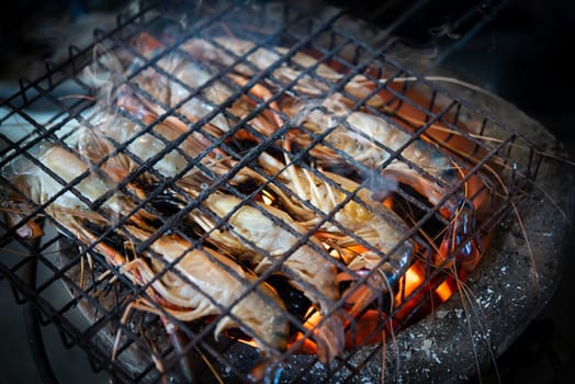 Grilled shrimp (Giant freshwater prawn) grilling with charcoal for sale at Thai street food market or restaurant in Bangkok Thailand